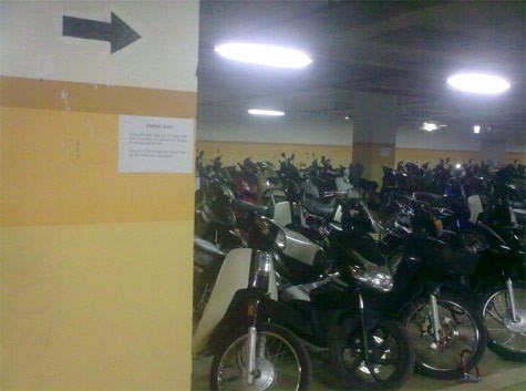 Bảng thông báo khách hàng tự bảo quản xe tại Grand Plaza chỉ được dán tạm bợ, khuất lấp như thế này. (Ảnh chụp hồi tháng 6/2011).