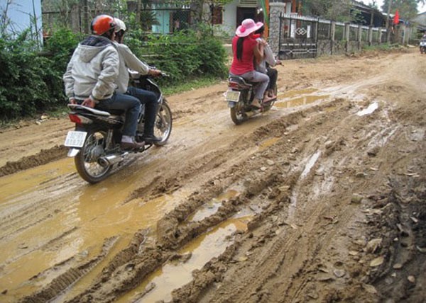 Đối với người dân miền Trung, do những đợt mưa to ngày đầu năm mới nên các con đường đất vào một số làng Quảng Nam vẫn rất còn ngập bùn nước, người dân phải xúng xính du xuân giữa những con đường lầy lội. (Ảnh: VNE).