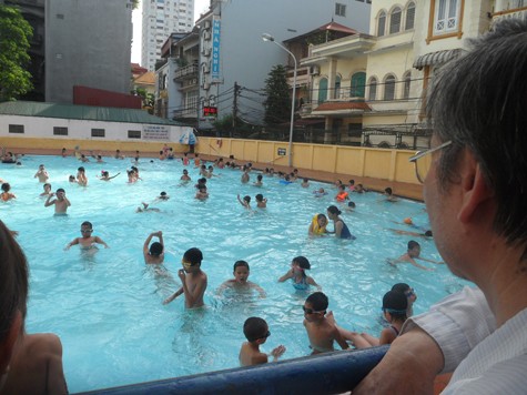 Nhiều gia đình còn đưa tất cả các thành viên đi "tránh nóng" tại các bể bơi đồng thời tranh thủ dạy con học bơi.