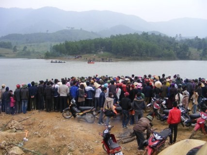 Hàng trăm người dân đang đứng trên bờ đập Cao Sơn theo dõi cuộc tìm kiếm thi thể hai vợ chồng anh Hiền