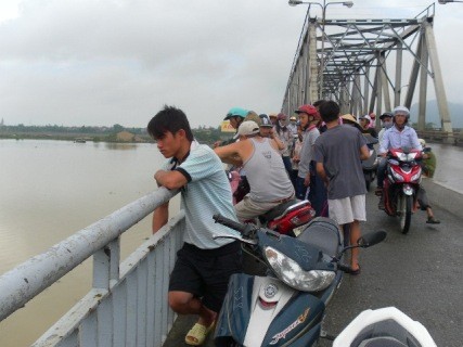 Nhiều người dân hiếu kỳ và gia đình nạn nhân đang tìm kiếm quanh vực cầu Bên Thủy nơi nghi ngờ em Anh tự tử