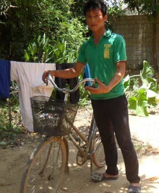 Em Ngô Văn Thuận bên chiếc xe đạp cọc cạch đã giúp em tạo nên kỳ tích trong đợt thi đại học vừa qua.