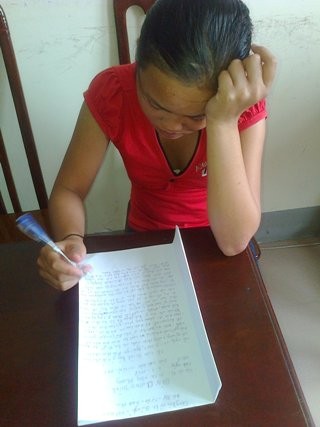 Cháu Lương Tiểu Y, một trong hai bé gái vừa được giải cứu thành công khỏi ổ mại dâm tại bãi biển Xuân Thành, Hà Tĩnh đang viết bản tường trình tại CQĐT.
