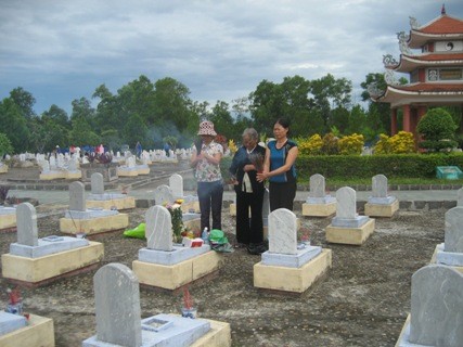 Gia đình thắp những nén hương lê phần mộ của người thân và các đồng đội đang an nghĩ tại nghĩa trang đường 9