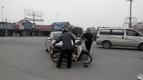 Mặc dù bị đau nhưng ông Hồng vẫn cố đứng dậy đưa chiếc xe máy của mình ra khỏi gầm xe ô tô của ông Dương