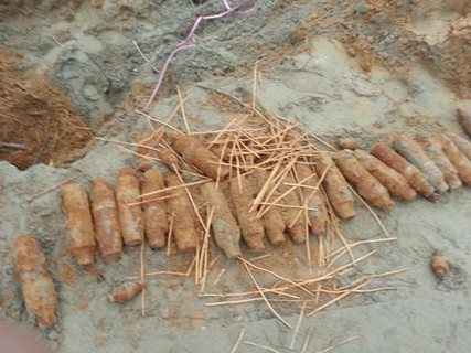 Hàng chục quả đạn pháo cùng dây dẫn nổ được phát hiện khi người dân đào móng xây tường rào