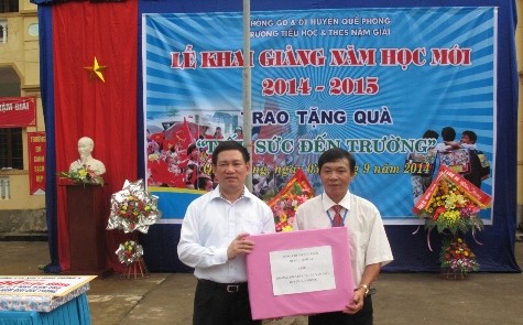 Ông Hồ Đức Pước trao quà cho đại diện trường tiểu học và trung học cơ sở xã Nậm Giải