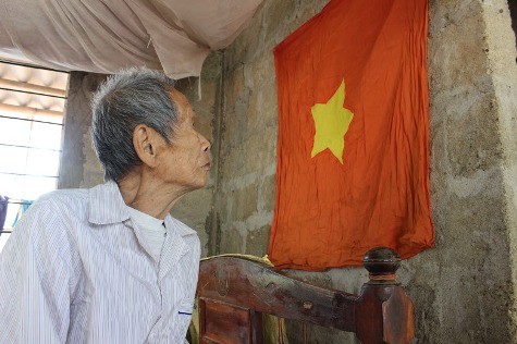 Ông Trần Xuân Thu nhìn lên lá cờ mà người đồng đội cùng quê tên Văn đã trao cho ông trước lúc hy sinh mỗi khi nhớ đến đồng đội cũ