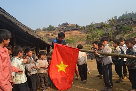 Thầy giáo và học sinh điểm lẻ bản Huồi Mới 1 đang treo cờ mới chuẩn bị cho lễ chào cờ đầu tuần ( ảnh Xuân Hòa)