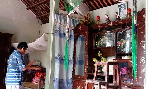Nhìn người con trai đầu của liệt sĩ Phan Huy Sơn bị bệnh động kinh, thiểu năng trí tuệ ngây ngô trước bàn thờ của bố mình không ai khỏi xót xa (ảnh Xuân Hòa)