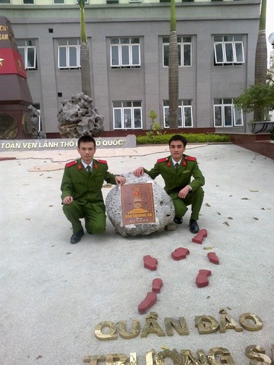 Thủ khoa Đào Đăng Việt (bên phải) chụp ảnh kỷ niệm tại hòn đá chủ quyền Hải quân Trường Sa tặng Học viện cảnh sát.