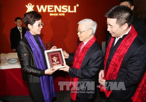 Tổng Bí thư Nguyễn Phú Trọng tặng quà lưu niệm cho Tập đoàn Vạn Sự Lợi. (Ảnh: Trí Dũng/TTXVN)