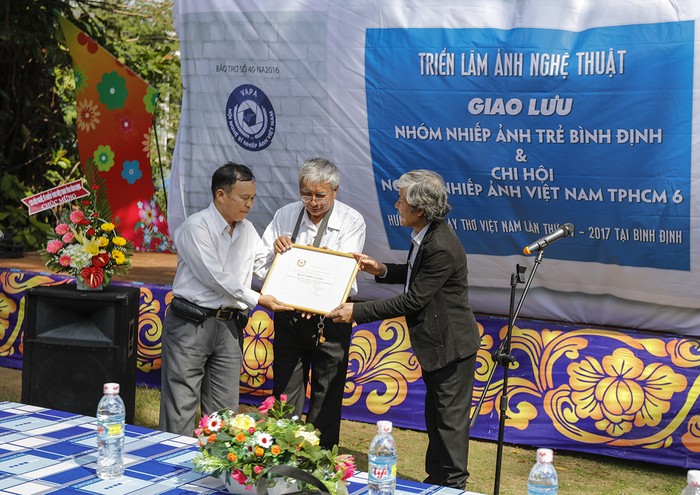 Nghệ sĩ nhiếp ảnh Đào Tiến Đạt – Uỷ viên Ban chấp hành Hội Nghệ sĩ nhiếp ảnh Việt Nam trao giấy bảo trợ của Hội Nhiếp ảnh Việt Nam.