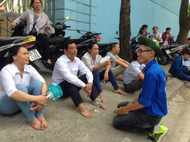 Bạn Nguyễn Đăng Thái Hoàng (sinh viên khoa Y dược Đại học Quốc gia Hà Nội) nhiệt tình mang nước uống cho các phụ huynh và trò chuyện về những lưu ý về quy chế thi năm nay.