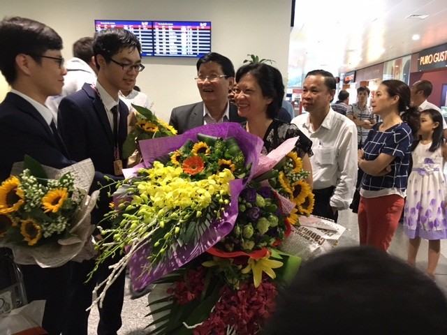 Các thầy cô tặng hoa chúc mừng hai em Trương Đông Hưng (thứ hai từ trái qua) và Dương Tiến Quang Huy (ngoài cùng bên trái).