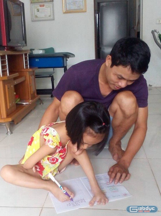 Bé Linh đang làm bài tập với sự hướng dẫn của bố.