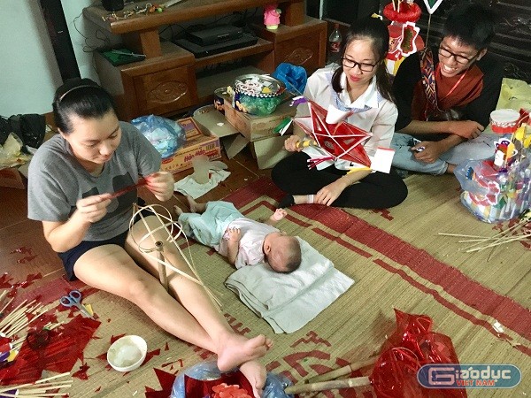 Chị Loan (trái), con gái thứ ba cùa bà Tuyến cho con gái 3 tháng tuổi đến nhà bố mẹ đẻ chơi và hỗ trợ ông bà làm đồ Trung thu. (Ảnh: Hồ Thu)