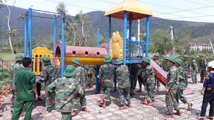 Bộ đội biên phòng Hà Tĩnh giúp trường mầm non dọn dẹp đồ chơi ngoài trời.