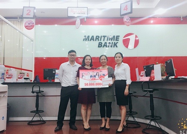 Chị Nguyễn Thị Phượng (thứ hai từ phải sang) đã may mắn nhận được sổ tiết kiệm Maritime Bank 50 triệu đồng đầu tiên của chương trình “Chọn Maritime Bank hôm nay, ngàn ưu đãi mỗi ngày”.