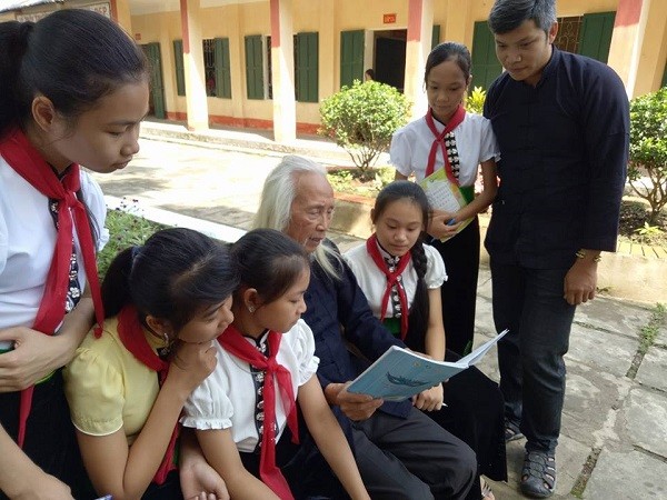 Thầy giáo Lê Thanh Tùng cùng với nghệ nhân Lò Văn Biến dạy chữ cho học sinh. (Ảnh: Nguyễn Nhật Thanh)