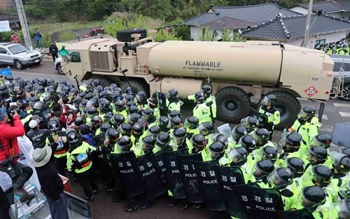 Cảnh sát Hàn Quốc ngăn chặn người biểu tình tiếp cận các xe chở thiết bị cấu thành THAAD tới điểm triển khai ở Seongju (Ảnh: CNN)