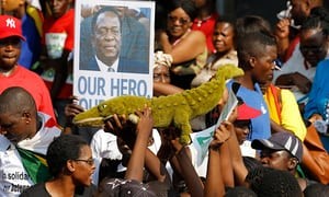Người dân Zimbabwe mang theo những tấm hình của vị tân Tổng thống để thể hiện sự ủng hộ đối với ông (Ảnh: CNN)