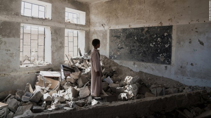 Cậu bé Yemen đứng trong một phòng học đổ nát (Ảnh: Reuters)