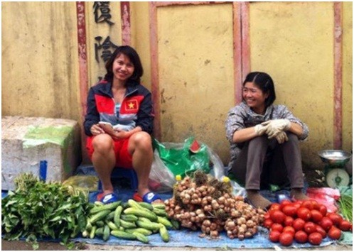 Nguyễn Thị Liễu (bên trái), thành viên đội tuyển nữ Việt Nam ngồi bán rau (ảnh chưa rõ tác giả)
