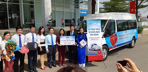Các đại diện của Vinamilk và Trung tâm hiến máu nhân đạo Thành phố Hồ Chí Minh bên cạnh xe hiến máu lưu động – món quà ý nghĩa mà Vinamilk trao tặng.