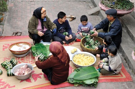 Các thành viên trong gia đình quây quần bên nhau cùng gói bánh chưng. (Ảnh: Baohaiphong.com.vn)