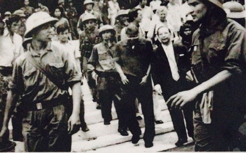Chiến sĩ Bàng Nguyên Thất (bìa phải) áp giải Dương Văn Minh ra Đài phát thanh để đọc lời tuyên bố đầu hàng. (Ảnh tư liệu)