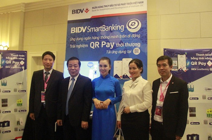 Phó Thống đốc Ngân hàng Nhà nước Nguyễn Kim Anh thăm gian triển lãm, trải nghiệm dịch vụ QR Pay và chụp ảnh lưu niệm với đại diện BIDV