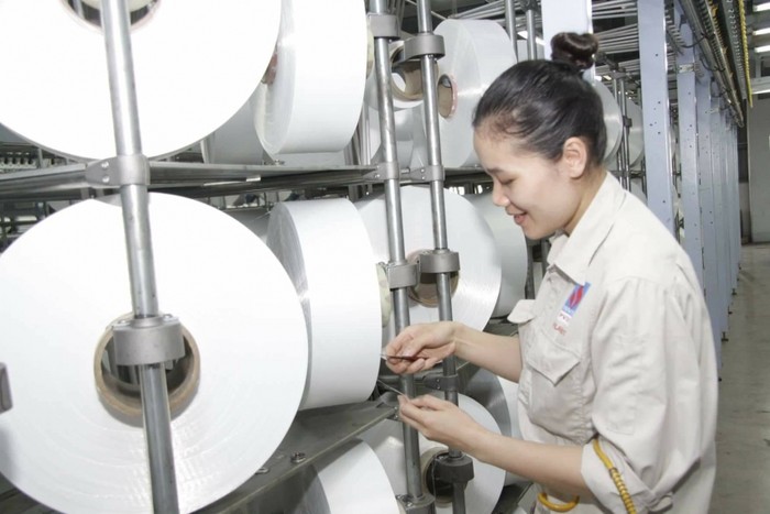 Công nhân kiểm tra chất lượng sợi Filament tại Nhà máy Xơ sợi Đình Vũ.