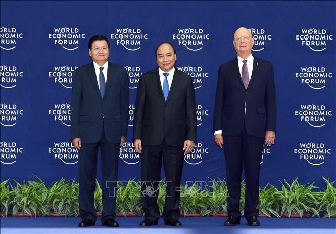 Thủ tướng Nguyễn Xuân Phúc (giữa) và Chủ tịch sáng lập WEF Klaus Schwab (bên phải) đón Thủ tướng Lào Thongloun Sisoulith đến dự hội nghị. Ảnh: Thống Nhất/TTXVN