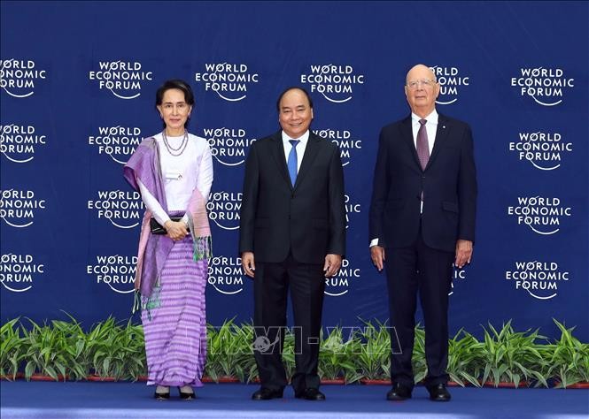 Thủ tướng Nguyễn Xuân Phúc (giữa) và Chủ tịch sáng lập WEF Klaus Schwab (bên phải) đón Cố vấn Nhà nước Myanmar, Bà Aung San Suu Kyi đến dự hội nghị. Ảnh: Thống Nhất/TTXVN