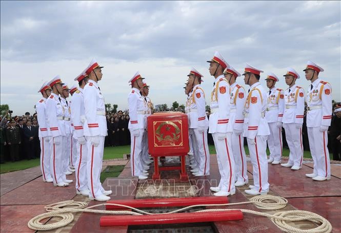 Các chiến sĩ trong đội nghi lễ thực hiện nghi thức hạ huyệt linh cữu Chủ tịch nước Trần Đại Quang. Ảnh: TTXVN