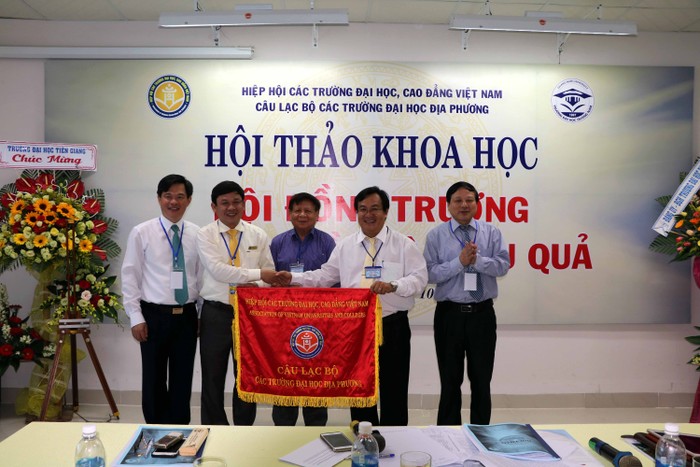 Phó giáo sư, Tiến sĩ Huỳnh Trọng Dương – Hiệu trưởng Trường Đại học Quảng Nam trao cờ luân lưu cho đại diện lãnh đạo Trường Đại học Tiền Giang