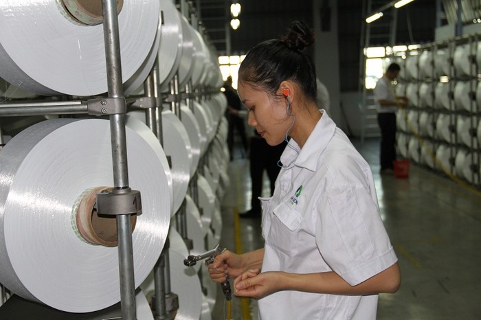 Công nhân vận hành dây chuyền sản xuất sợi DTY tại Nhà máy Xơ sợi Đình Vũ.