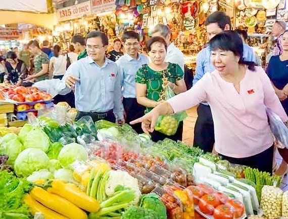 Các thành viên Hội đồng nhân Thành phố Hồ Chí Minh khảo sát tại một quầy bán rau củ quả ở chợ Bến Thành.