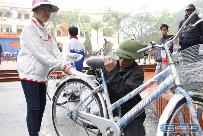 Bố em Tô Thị Nhung - học sinh lớp 8A Trường Trần Phú sau khi nhận xe đạp đã hạ thấp yên xe để phù hợp với con gái.
