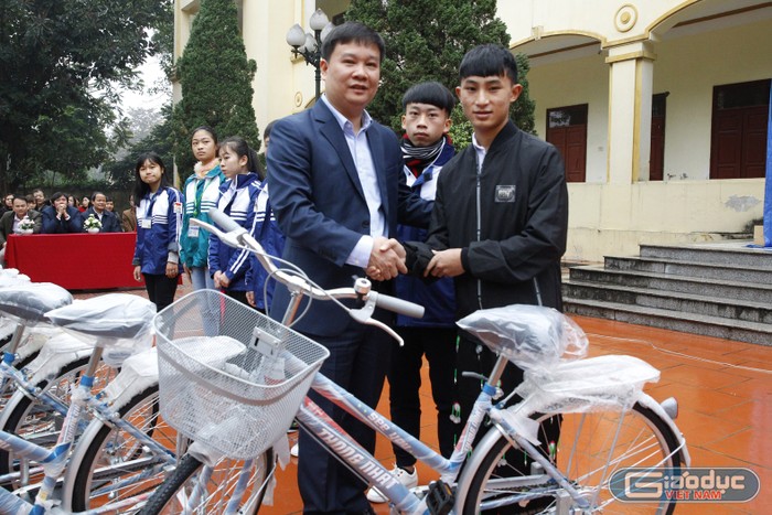 Ông Nguyễn Tiến Bình, Tổng biên tập Báo Điện tử Giáo dục Việt Nam trao tặng xe đạp cho học sinh người dân tộc H’Mông - em Sùng A Chi, học sinh lớp 12D Trường dân tộc nội trú của tỉnh Phú Thọ.