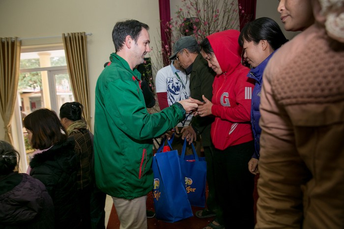 Ông Matt Wilson, đại diện Heinneken Việt Nam, tặng quà và chúc Tết các hộ nghèo