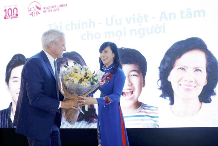 Ông Wayne Besant - Tổng giám đốc AIA Việt Nam tặng hoa cảm ơn bà Trần Tuấn Anh - thành viên Hội đồng quản trị kiêm Tổng giám Đốc Kienlongbank