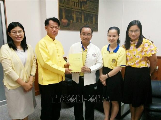Tiến sĩ Boonlue Chaimano, Chủ nhiệm bộ môn tiếng Thái thuộc Đại học Lampang Rajabhat tặng sách cho Hiệu trưởng Đại học Lampang Rajabhat Somkiat Saithanoo. Ảnh: Ngọc Quang/PV TTXVN tại Thái Lan