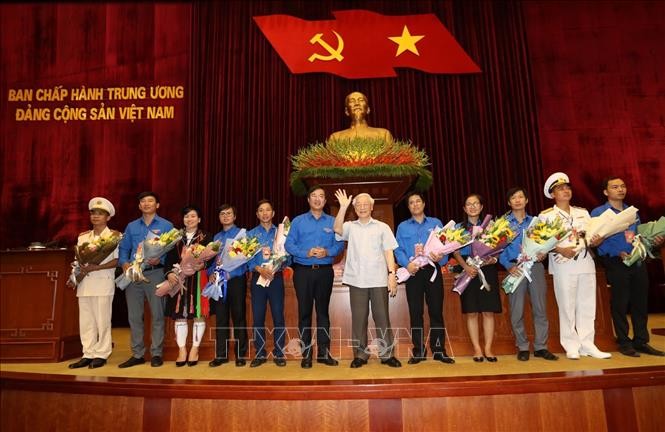 Tổng Bí thư, Chủ tịch nước Nguyễn Phú Trọng tặng hoa các đảng viên trẻ tiêu biểu. Ảnh: Trí Dũng/TTXVN