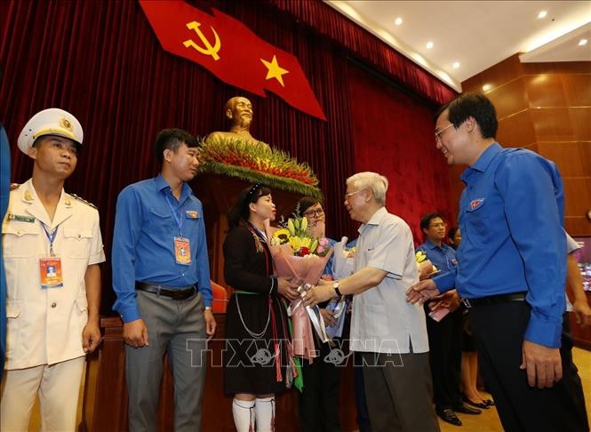 Tổng Bí thư, Chủ tịch nước Nguyễn Phú Trọng tặng hoa các đảng viên trẻ tiêu biểu. Ảnh: Trí Dũng/TTXVN