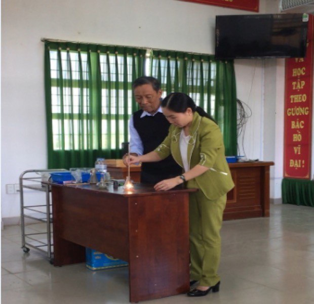 Thầy Trần Trọng Chấm, 83 tuổi, đang hướng dẫn giáo viên thực hiện thí nghiệm bằng dụng cụ cải tiến