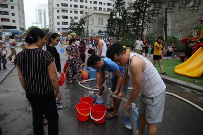 Người dân ở Khu đô thị Linh Đàm xếp hàng chờ lấy nước sạch, vì không thể sử dụng nước của Công ty Sông Đà bị nhiễm dầu. ảnh: Thế Đại.
