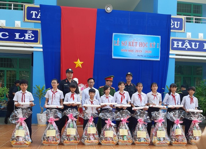 Đồng chí Nguyễn Tứ Hải (bìa trái), Phạm Khắc Nhẫn (bìa phải) chụp ảnh lưu niệm với học sinh nhận quà xuân