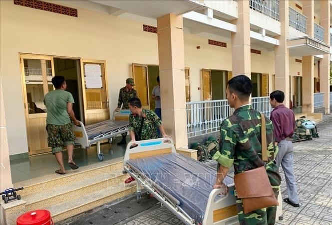 Cán bộ, chiến sĩ Trung đoàn Gia Định (Bộ Tư lệnh TP Hồ Chí Minh) đưa giường bệnh vào khu vực Bệnh viện dã chiến. Ảnh: TTXVN phát